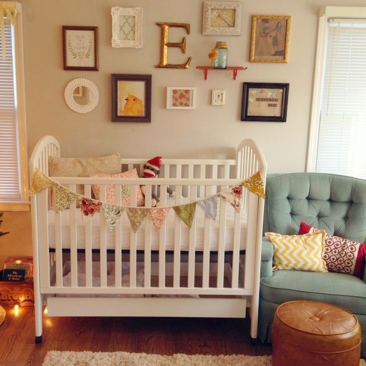 Chambre bébé fille bohème avec fauteuil vert et lit blanc
