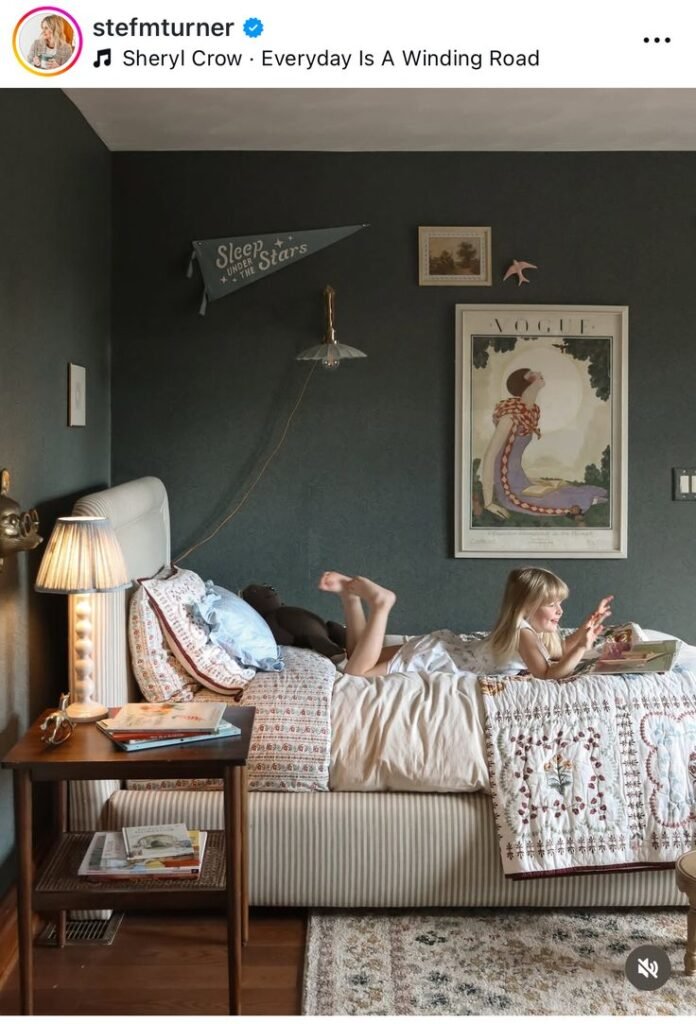 Chambre enfant rétro avec fille sur le lit mur bleu gris et lampe ancienne