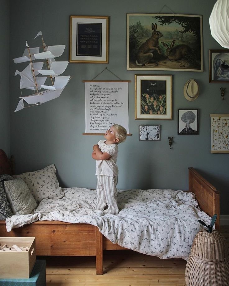 Chambre enfant rétro avec petit garçon murs verts de gris et bateau suspendu_