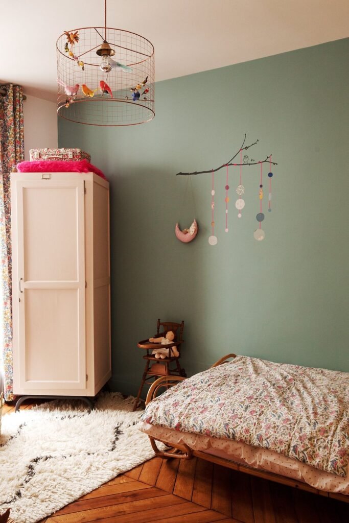 Chambre enfant vintage avec parure de lit a fleurs et mur vert sauge