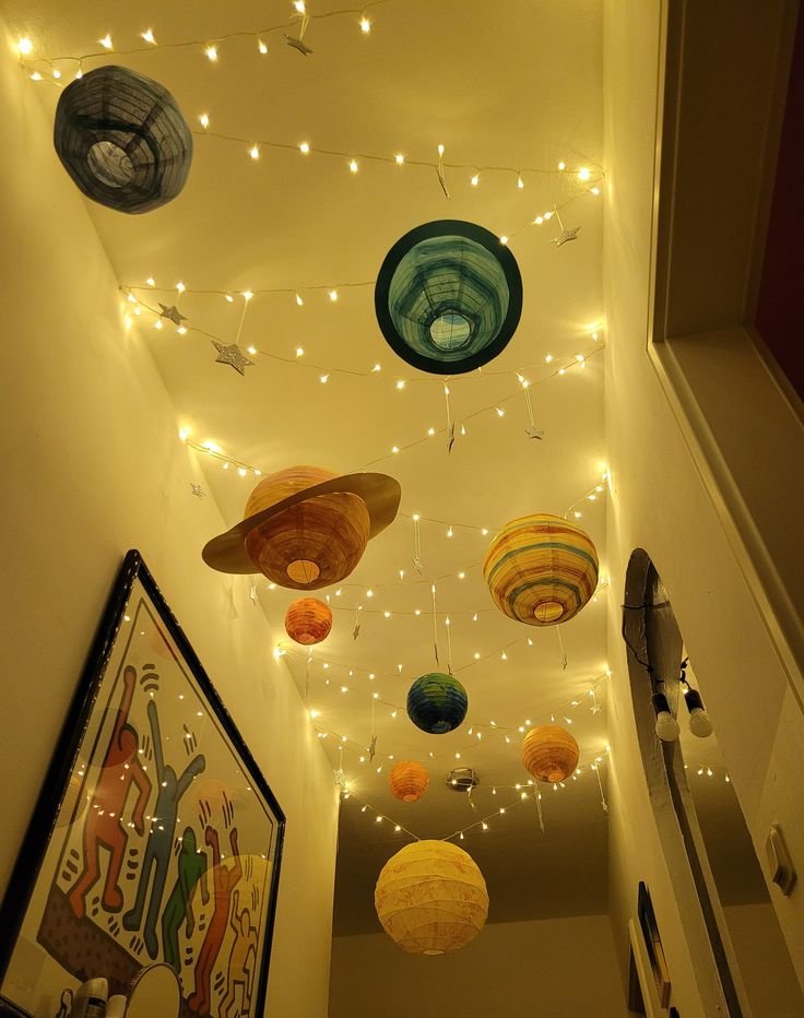 Idée déco pour chambre enfant thème espace avec planètes suspendues et guirlandes