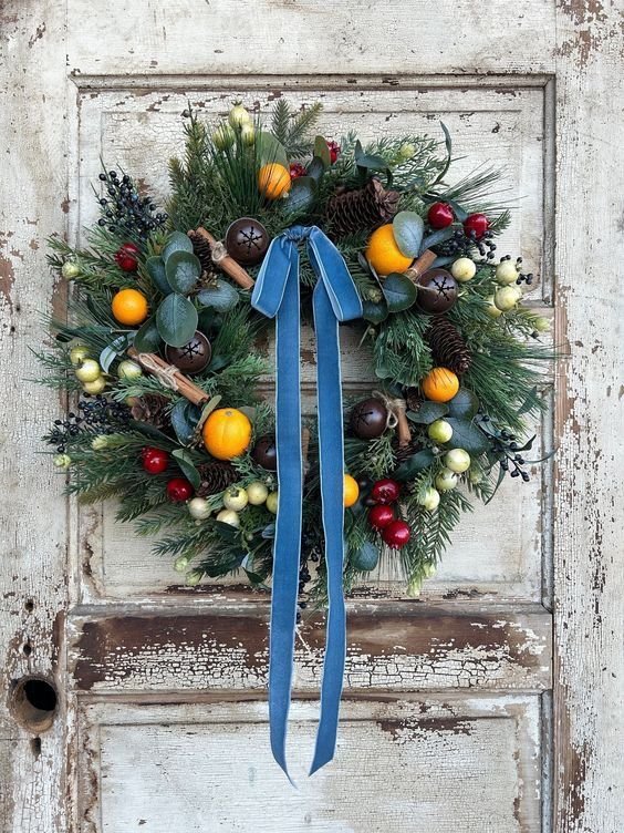 Couronne de Noël avec ruban bleu boules de houx et mandarines