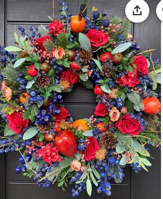 Couronne de Noël colorée avec roses rouges oranges et pommes de pin