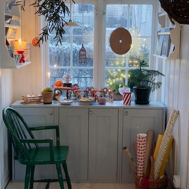 Déco fenêtre Noël avec plantes et étoiles suspendues au dessus placard