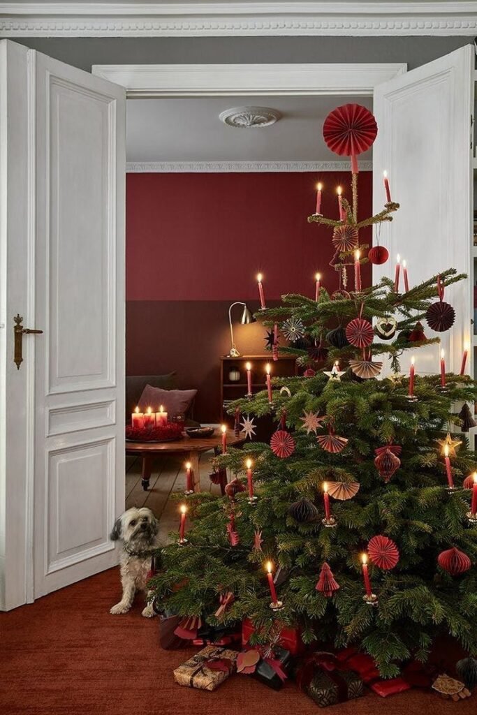 Déco maison sapin de noël rouge et doré avec bougies dans salon rouge chic