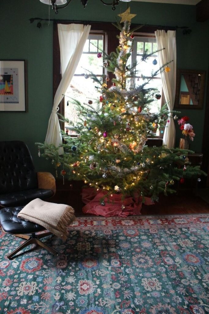 Déco sapin de Noël en doré dans salon vert avec grand tapis persan vert