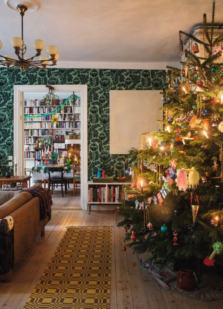 Deco-sapin-de-noel-2025-avec-guirlande-de-drapeaux-et-bougies-dans-salon-vert