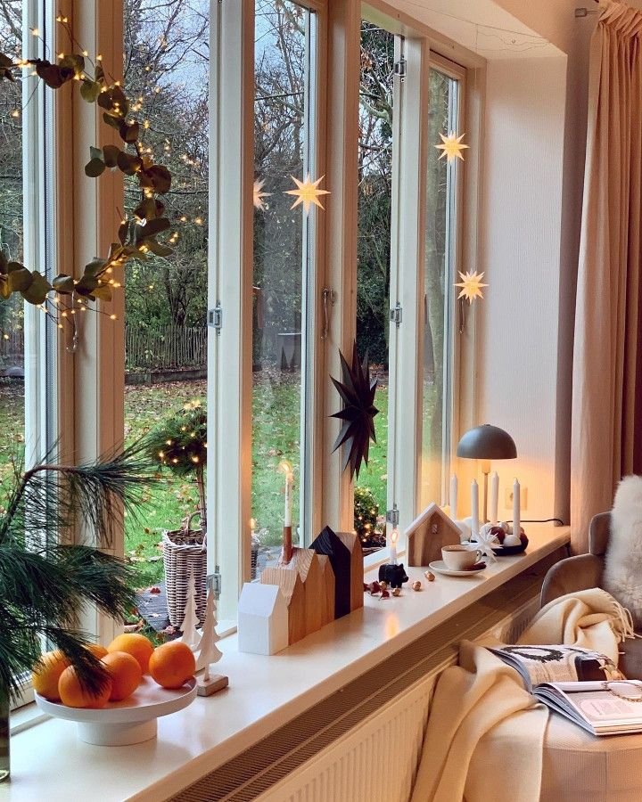 Deco-style-scandinave-de-fenetre-de-Noel-avec-petites-maisons-etoiles-et-lampe