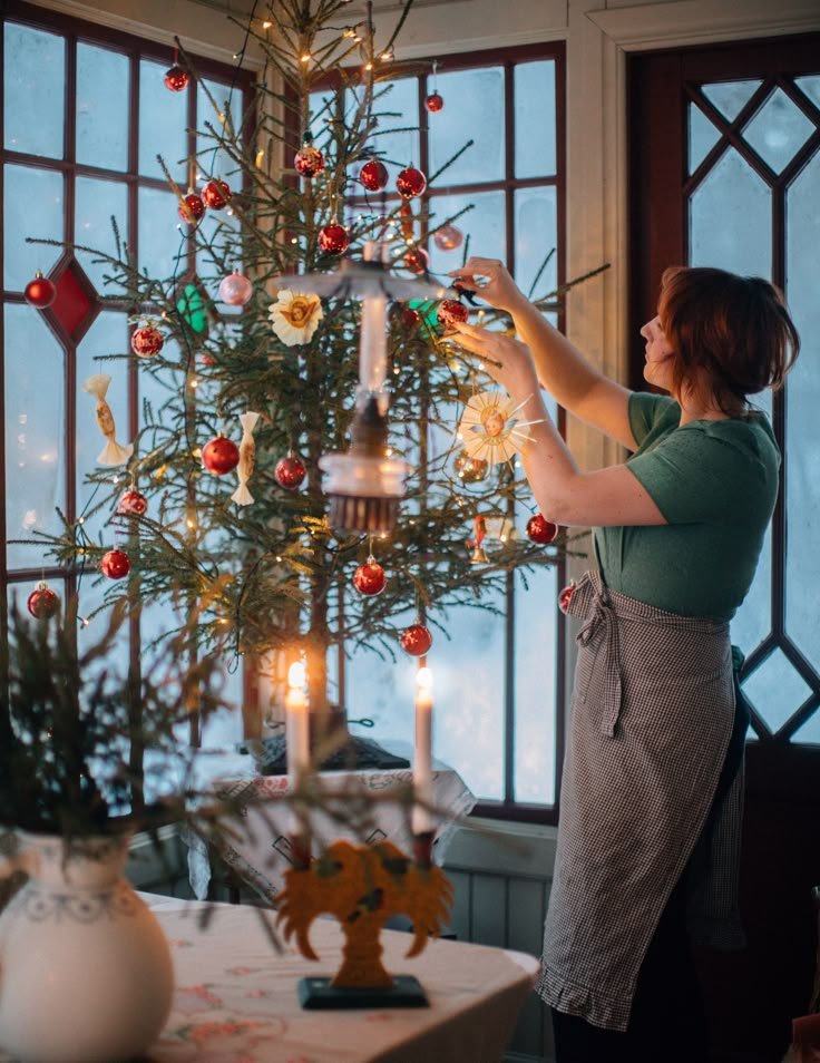 Décoration de Noël devant fenêtre sapin de Noël décoré boules rouges avec femme