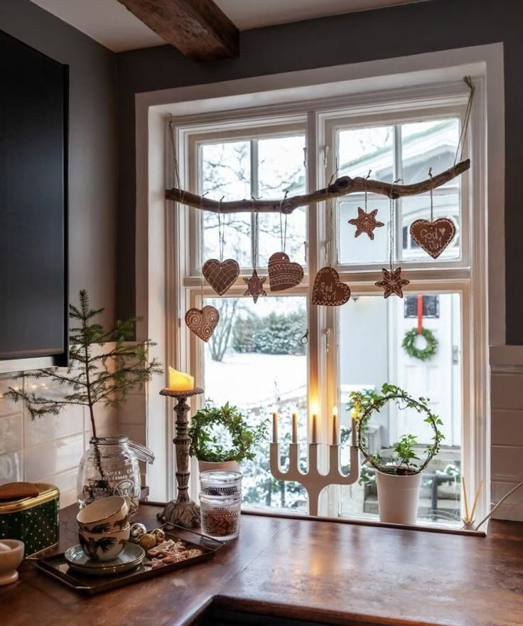 Décoration fenêtre de Noël avec couronne de branche avec bougie et coeurs suspendus_