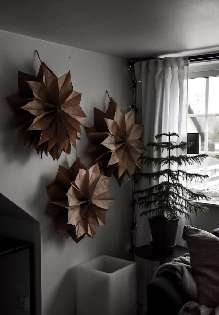 Etoiles de Noel en papier accrochées au mur dans interieur scandinave