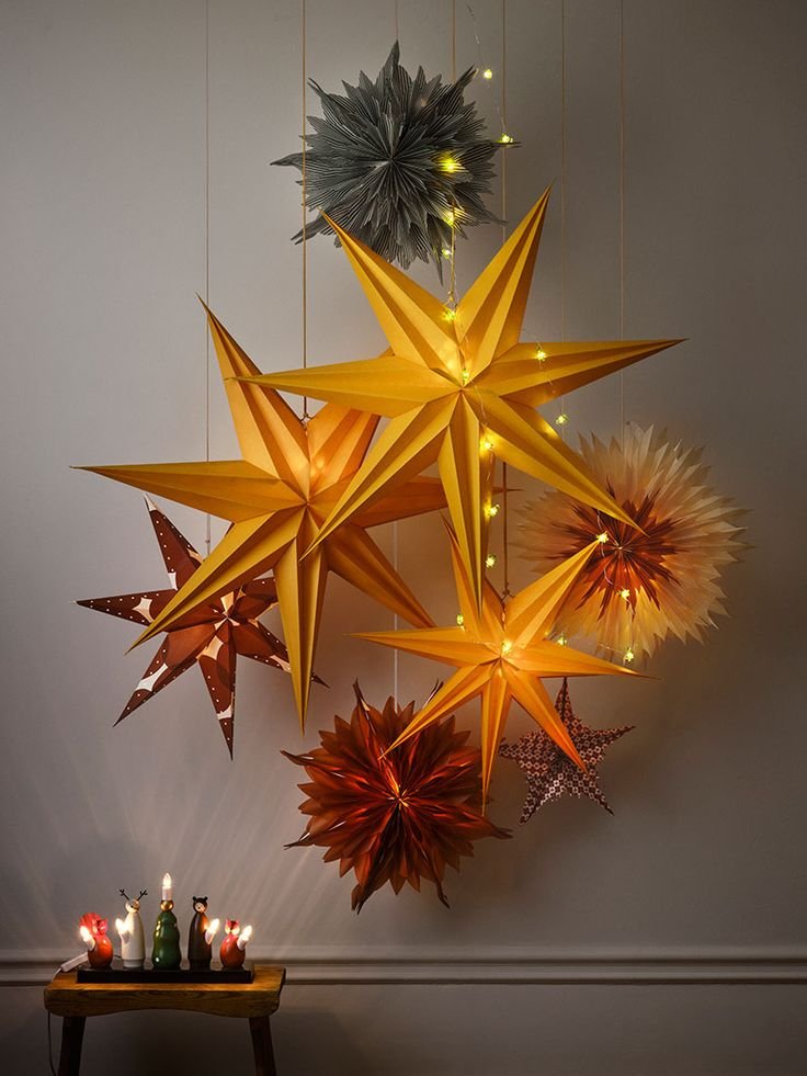 Etoiles de Noel lumineuses suspendues au mur avec bougies