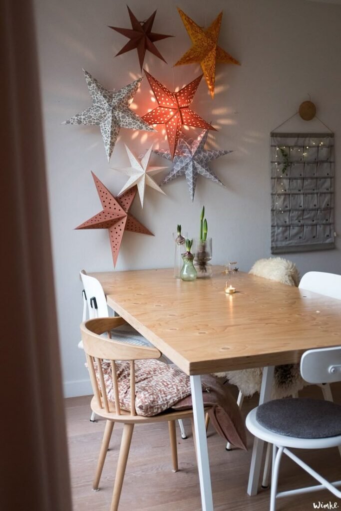 Etoiles de Noel orange et marron suspendues au dessus de la table de salle a manger