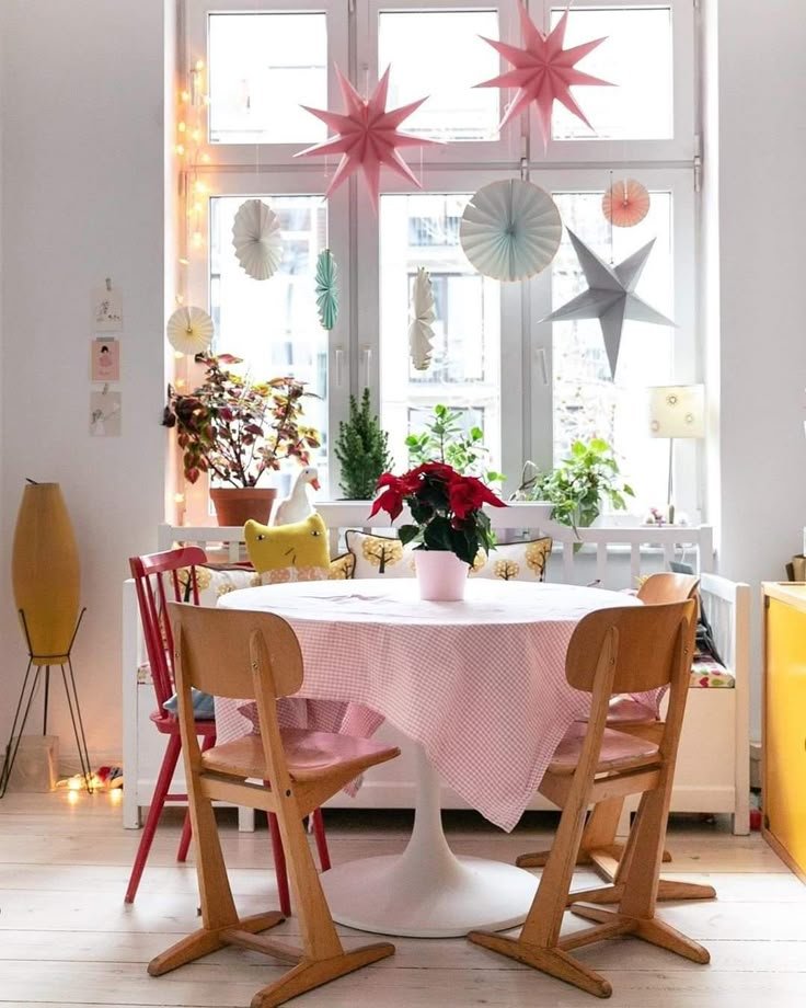 Etoiles de Noel suspendues derriere la fenetre dans salle a manger scandinave table tulipe