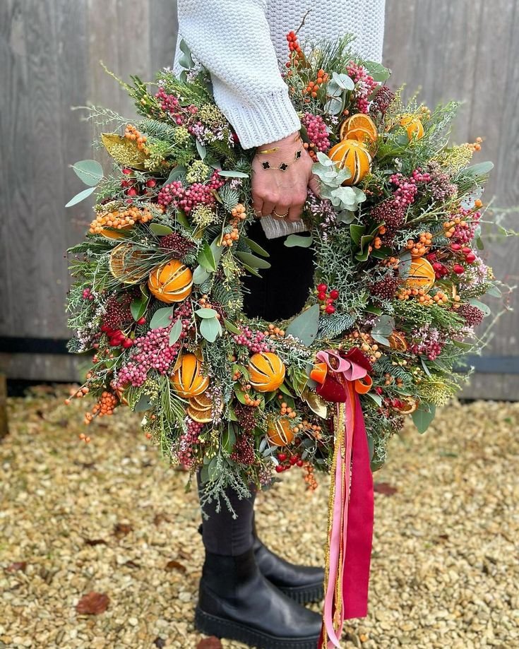 Fabrication d_une couronne de Noël orange fleurs roses et ruban rouge