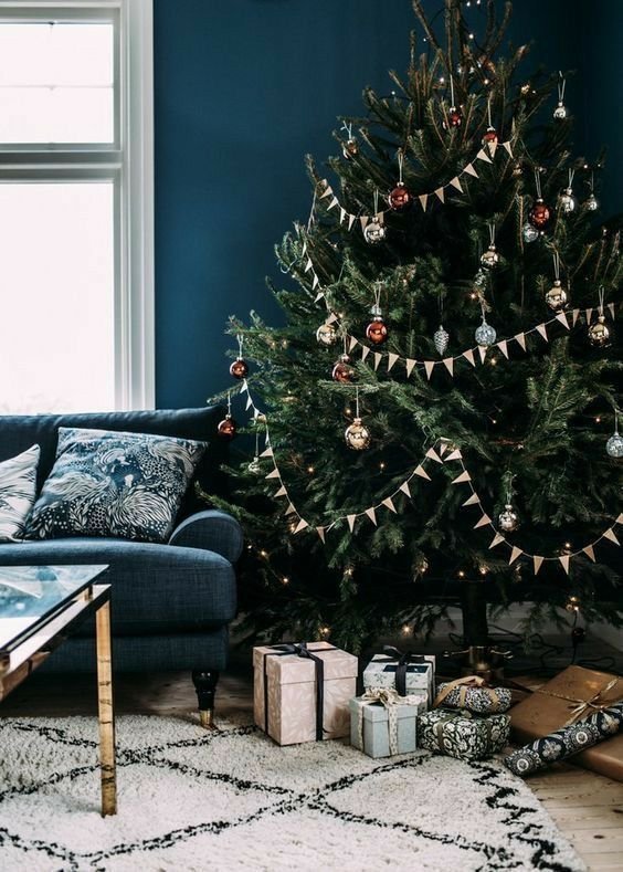 Inspiration sapin de noël dans salon bleu avec déco argentée et rouge