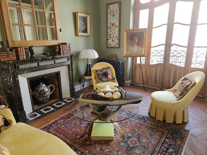 Salon-classique-chic-avec-fauteuils-crapaud-et-cheminee-ancienne-duplex-Vichy