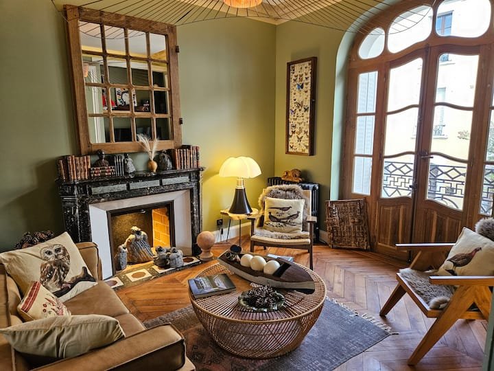 Salon classique chic avec fenêtre art nouveau arabesques canapé marron et lampe pipistrello