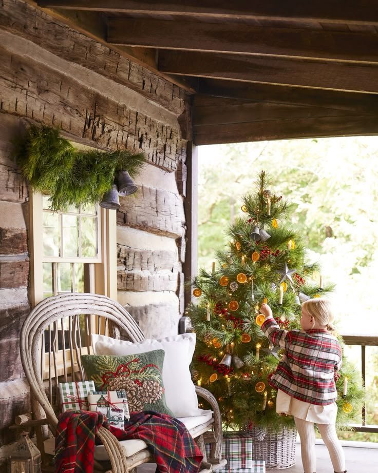 Terrasse chalet de noël avec sapin décoré avec oranges séchées country Living magazine