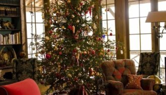 Veranda décorée pour Noël dans chalet avec fauteuil et sapin