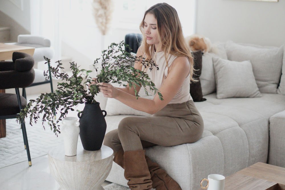 So Andy assise dans son salon couleurs beiges et blanches